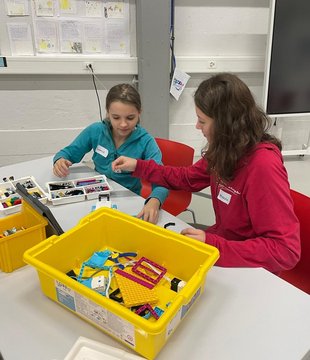 Zwei Mädchen bauen mit LEGO in einem Klassenzimmer