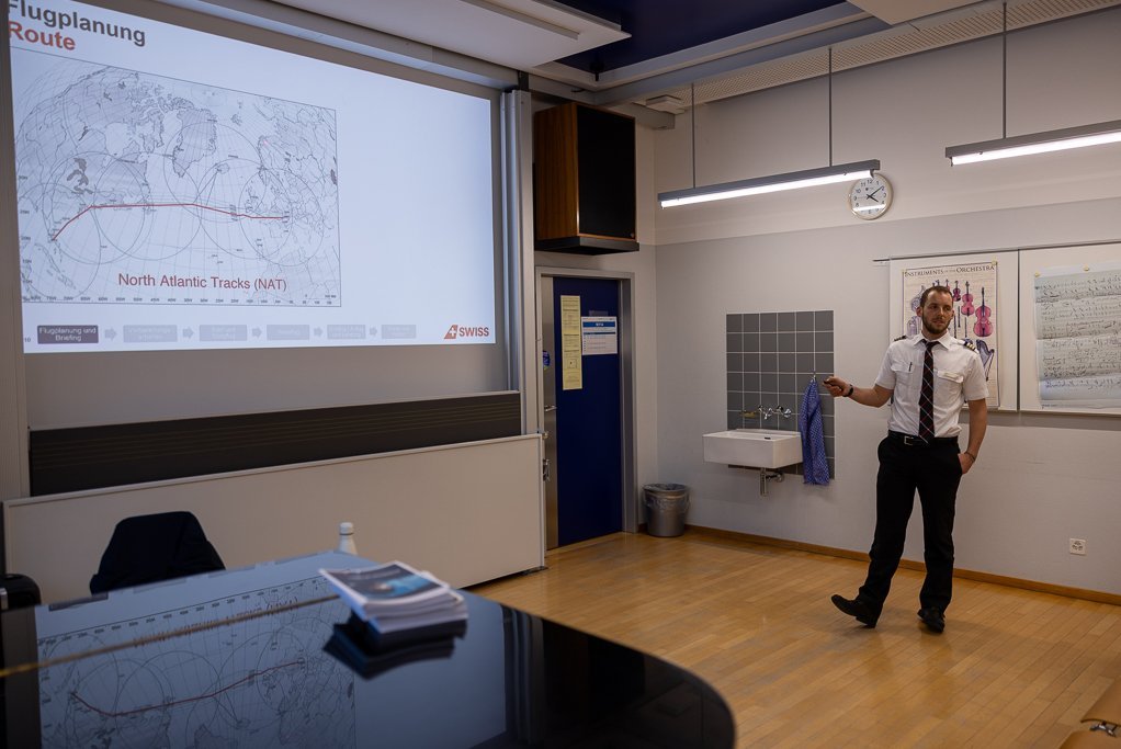 Pilot präsentiert Flugplanung vor einer Karte.