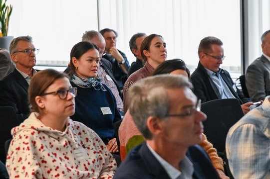 Menschen in einem Konferenzraum, die aufmerksam zuhören