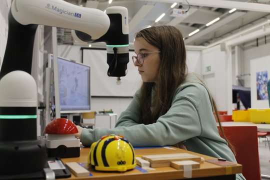 Mädchen testet Technik mit einem Roboterassistenten