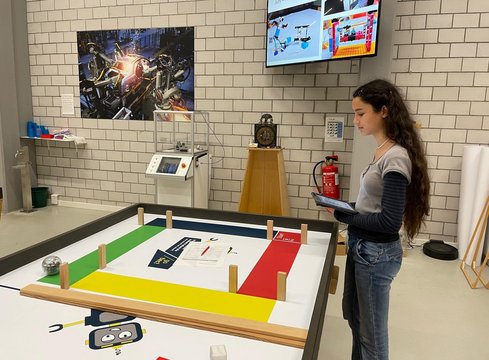 Mädchen mit Tablet neben einem farbigen Spielfeld